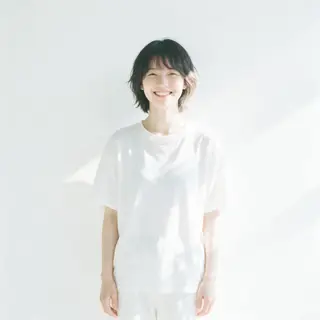 A high-key portrait of a person against a bright white backg