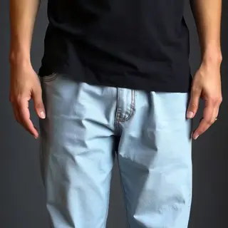 A person standing with both hands visible at their sides, fi