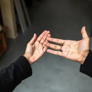 Two people doing a high-five, palms meeting with all fingers