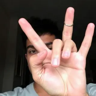 A person making a peace sign with their right hand, clearly 
