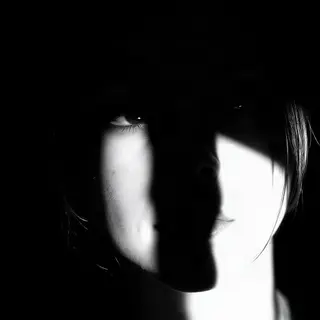 A portrait with dramatic split lighting — half the face brig