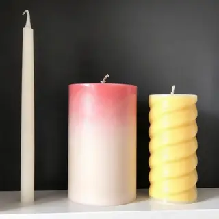 A tall thin white candle, a short fat red candle, and a medi
