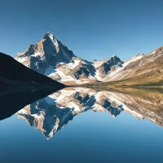 A mountain range reflected in a still alpine lake, with the 