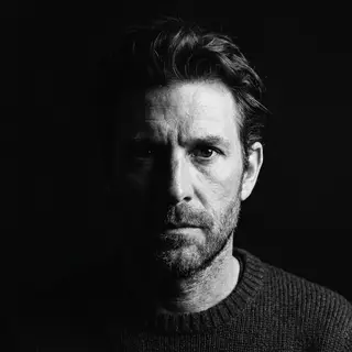 A portrait with dramatic split lighting — half the face brig