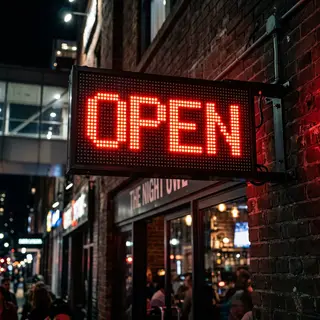 The word 'OPEN' displayed on a red LED sign with glowing pix