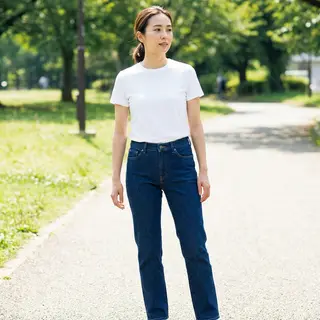A woman standing upright in a relaxed pose, arms at her side