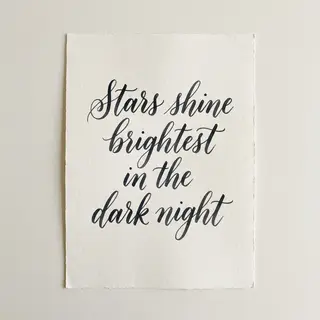 'Stars shine brightest in the dark night' displayed on a cle