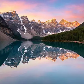 A mountain range reflected in a still alpine lake, with the 