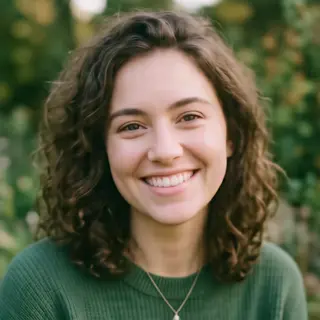 A close-up portrait of a young woman with a warm natural smi