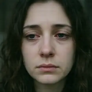 A face showing quiet melancholy — downcast eyes, slightly dr