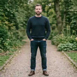 A man standing straight facing the camera, hands in pockets,