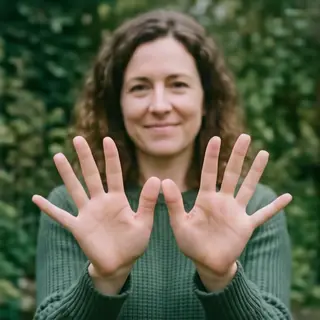 A woman holding her hands out in front of her palms-up, all 