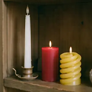 A tall thin white candle, a short fat red candle, and a medi