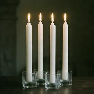 Exactly 4 white candles standing on a dark surface