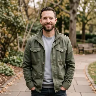 A man standing straight facing the camera, hands in pockets,