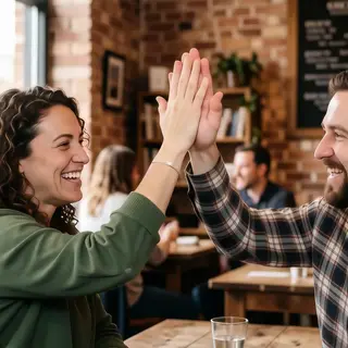Two people doing a high-five, palms meeting with all fingers
