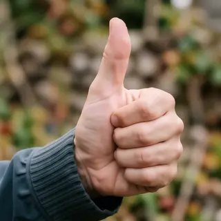 A hand giving a thumbs-up with four fingers curled and thumb