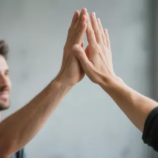 Two people doing a high-five, palms meeting with all fingers