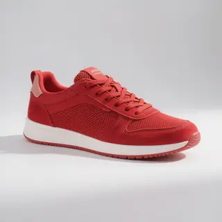 A single red sneaker on a clean white background with soft s