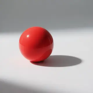 A red sphere on a white surface with a single shadow cast to