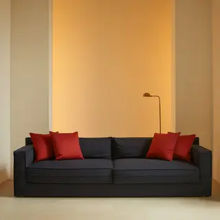A minimalist room with walls in #F5E6CC (warm cream), a sofa
