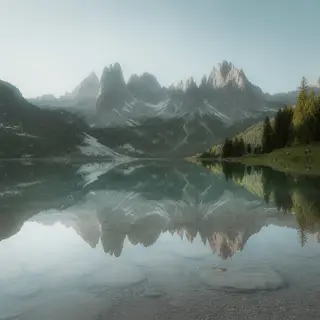A mountain range reflected in a still alpine lake, with the 