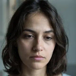 A face showing quiet melancholy — downcast eyes, slightly dr