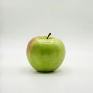 A ripe green apple on a seamless white background with soft 