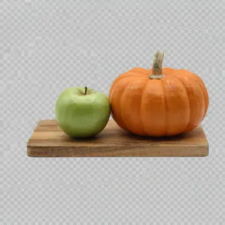 A green apple and an orange pumpkin on a wooden cutting boar