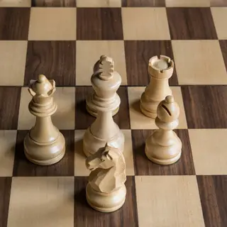Five chess pieces on a board: a king in the center, a queen 