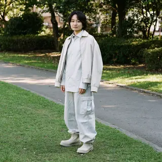 A person standing in a neutral pose in a park, full body vis