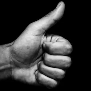 A hand giving a thumbs-up with four fingers curled and thumb