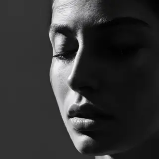 A portrait with dramatic split lighting — half the face brig