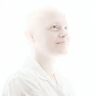 A high-key portrait of a person against a bright white backg
