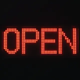 The word 'OPEN' displayed on a red LED sign with glowing pix