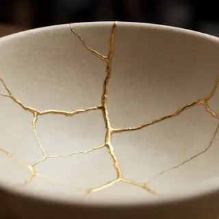 A Japanese kintsugi bowl — cracked ceramic repaired with vis