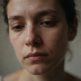 A face showing quiet melancholy — downcast eyes, slightly dr