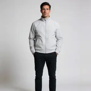 A man standing straight facing the camera, hands in pockets,