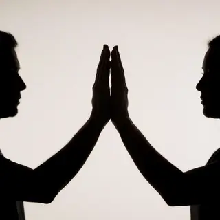 Two people doing a high-five, palms meeting with all fingers