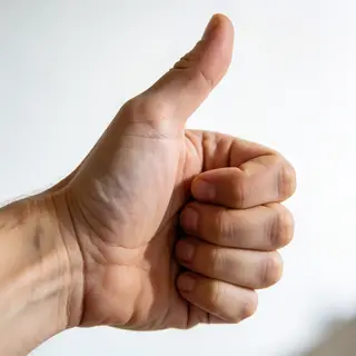 A hand giving a thumbs-up with four fingers curled and thumb