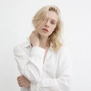 A high-key portrait of a person against a bright white backg