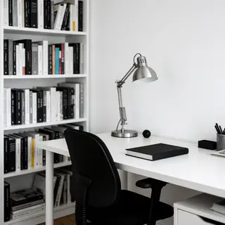 An office workspace with a desk, chair, bookshelf, and lamp 