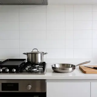 A kitchen with pots, pans, a stove, and a cutting board but 