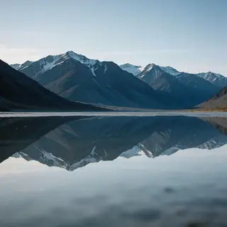 A mountain range reflected in a still alpine lake, with the 
