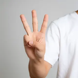 A person counting to three on their fingers, with index, mid