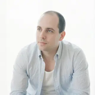 A high-key portrait of a person against a bright white backg