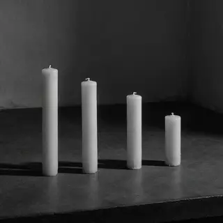 Exactly 4 white candles standing on a dark surface