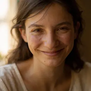 A close-up portrait of a young woman with a warm natural smi