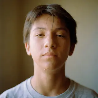 A headshot of a teenager with a relaxed, neutral face