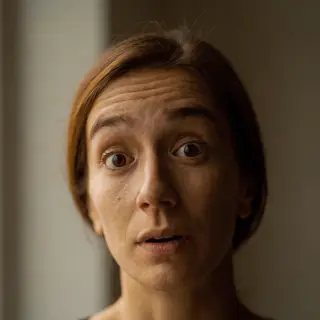 A portrait capturing genuine surprise — raised eyebrows, wid